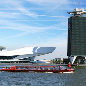 AMSTERDAM, HOLLAND - AUGUST 01: EYE Film Institute and Overhoeks Tower in Amsterdam, Holland. August 01, 2012 Amsterdam, Holland. EYE Film Institute includes a cinematography museum.; Shutterstock ID 111061883; Your name (First / Last): Daniel Fahey; GL account no.: 65050; Netsuite department name: Online Editorial; Full Product or Project name including edition: Amsterdam-Noord neighbourhood