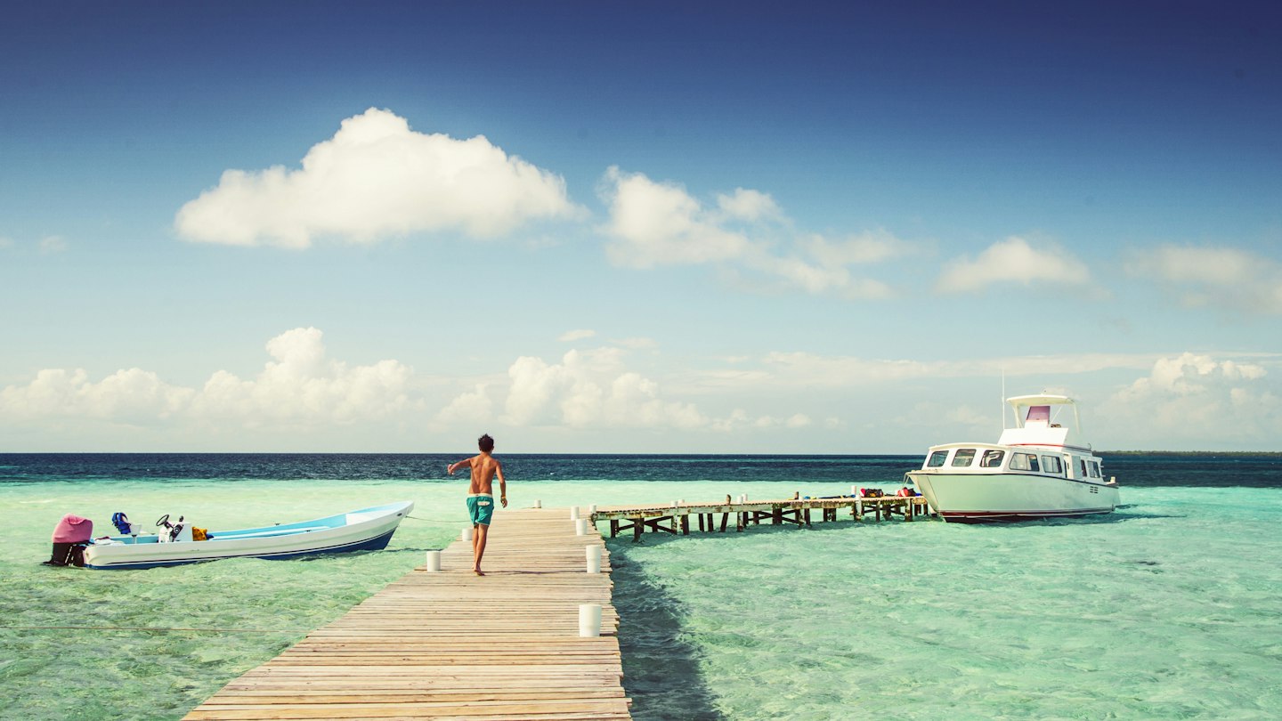 Boy in swimming trunks, walking on jetty on a hot, sunny day
825472850