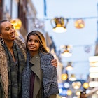 Two black women embracing as they walk down the street in Amsterdam