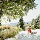 Woman performing yoga on pool deck of home