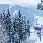 Ski lift - happy skiers in ski resort