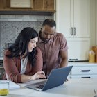 Caucasian woman and African American man sit at kitchen counter with breakfast working with pen, paper and laptop. - stock photo
Caucasian woman and African American man sit at kitchen counter with breakfast working with pen, paper and laptop.