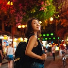 Young female traveller exploring local market at night in Vietnam during Chinese New Year. Solo traveller. Travel like a local.
1450014803
Young Asian woman with a backpack walking through a night market in Vietnam