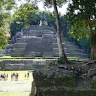 Wide shot of tourists dwarfed by the Temple of the Jaguar Mayan pyramid in Lamanai, Belize
1481511269