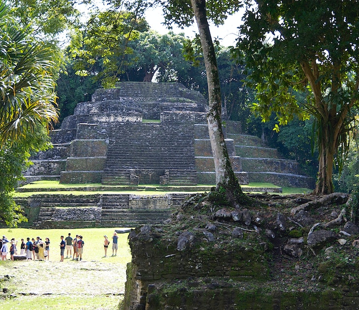 Wide shot of tourists dwarfed by the Temple of the Jaguar Mayan pyramid in Lamanai, Belize
1481511269