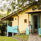 A woman enjoying a cup of coffee outside a cottage in Costa Rica.