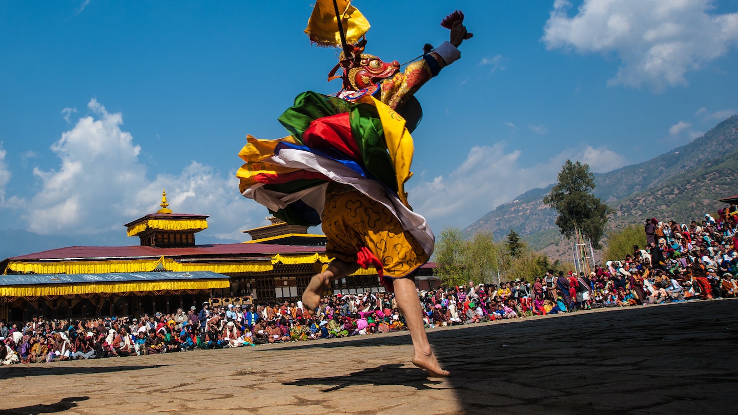 A person in traditional dress dancing at the Paro Tsechu festival, Bhutan