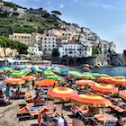 Beachgoers relaxing under umbrellas on the Amalfi Coast. Image by Mark Waind / EyeEm / Getty