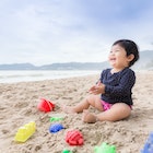 Baby girl laughing on the beach. Can use for learning and playing concept.
876796254