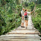 Couple with backpack hiking in rainforest