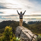 Rear View Of Man With Arms Raised Standing On Rock At Cerro Chirripo