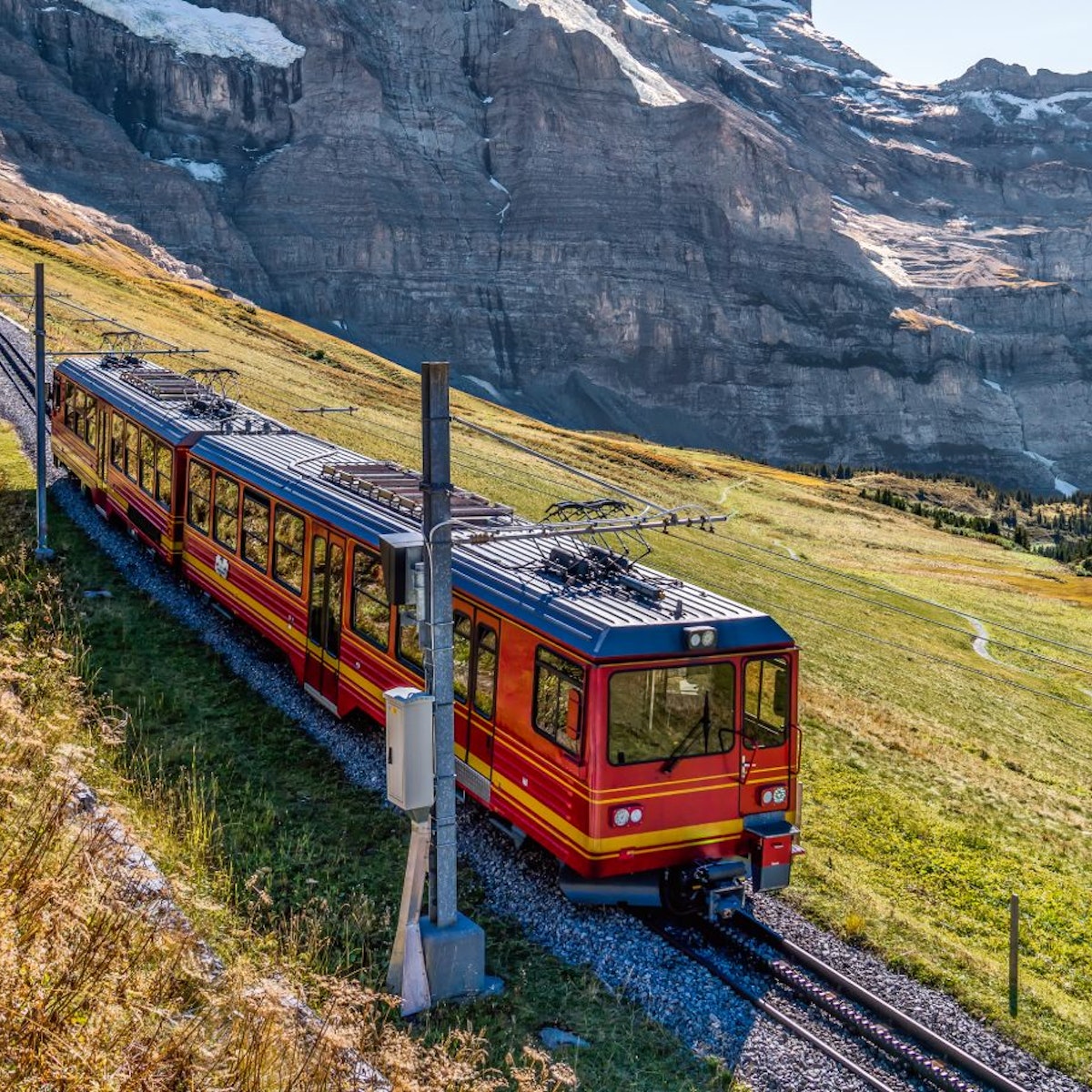 The red train running on the Jungfrau railway with a background view of Jungfrau