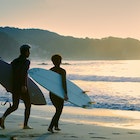 Active senior husband and wife love playing Surfing in Early morning at Izu Peninsula UNESCO Global Geopark Japan