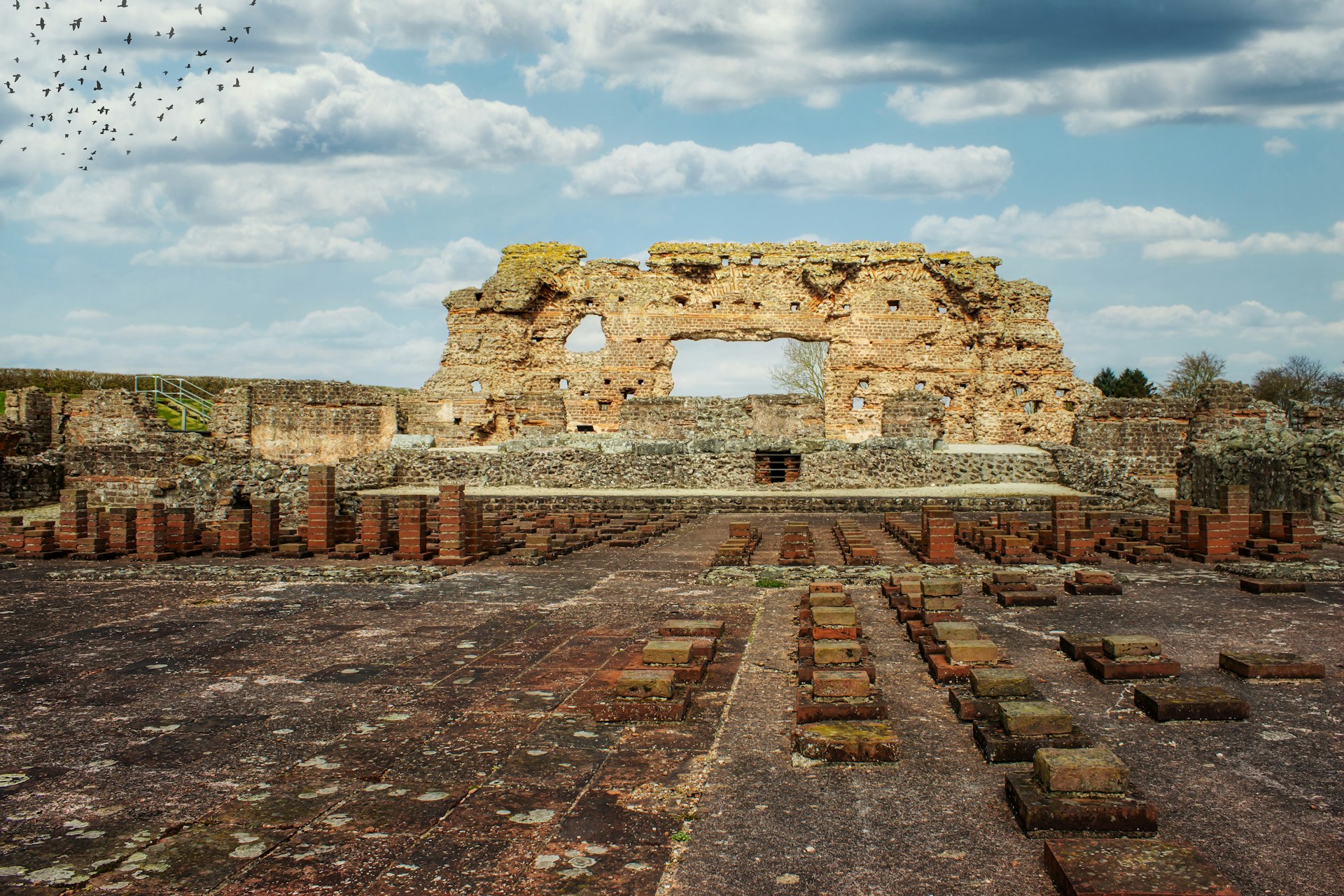 The wall of an old Roman structure stands beneath a blue sky