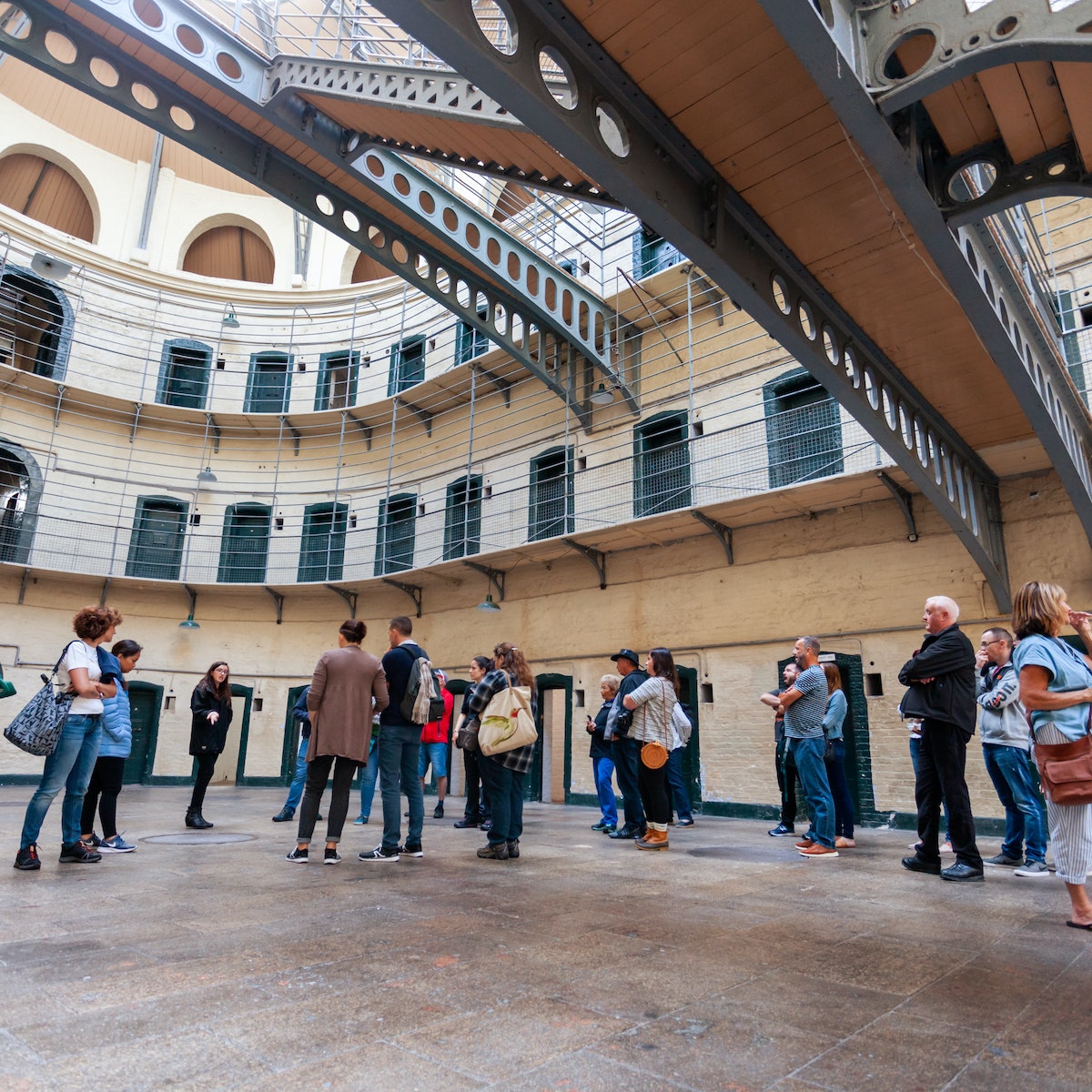 August 2019: A tour group on the floor of the Victorian main hall in the Kilmainham Gaol, a former prison which is now a museum. 