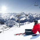 Girl skier lying on snow with ski, French Alps High mountain