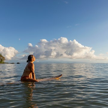 Stock Photo of Beautiful Hispanic female surfer in Costa Rica at sunrise