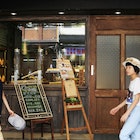 Two people walk past a small cafe in Taipei