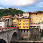 View of bridge over Mastallone river, red geraniums on railing. Ancient mountain town, in the Italian region of Piedmont, cloudy evening mood with Sacro Monte buildings on the hill behind. Important tourist resort.
1091344436