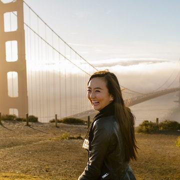 Woman in front of Golden Gate Bridge at sunrise in San Francisco